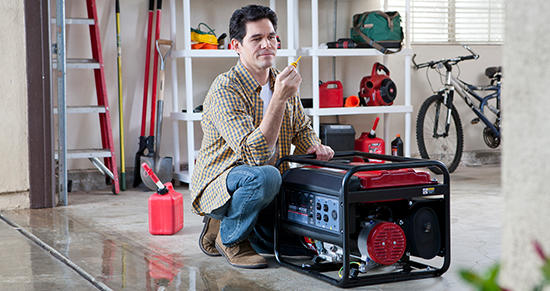 Man kneeling next to an electric generator in a garage, checking the oil