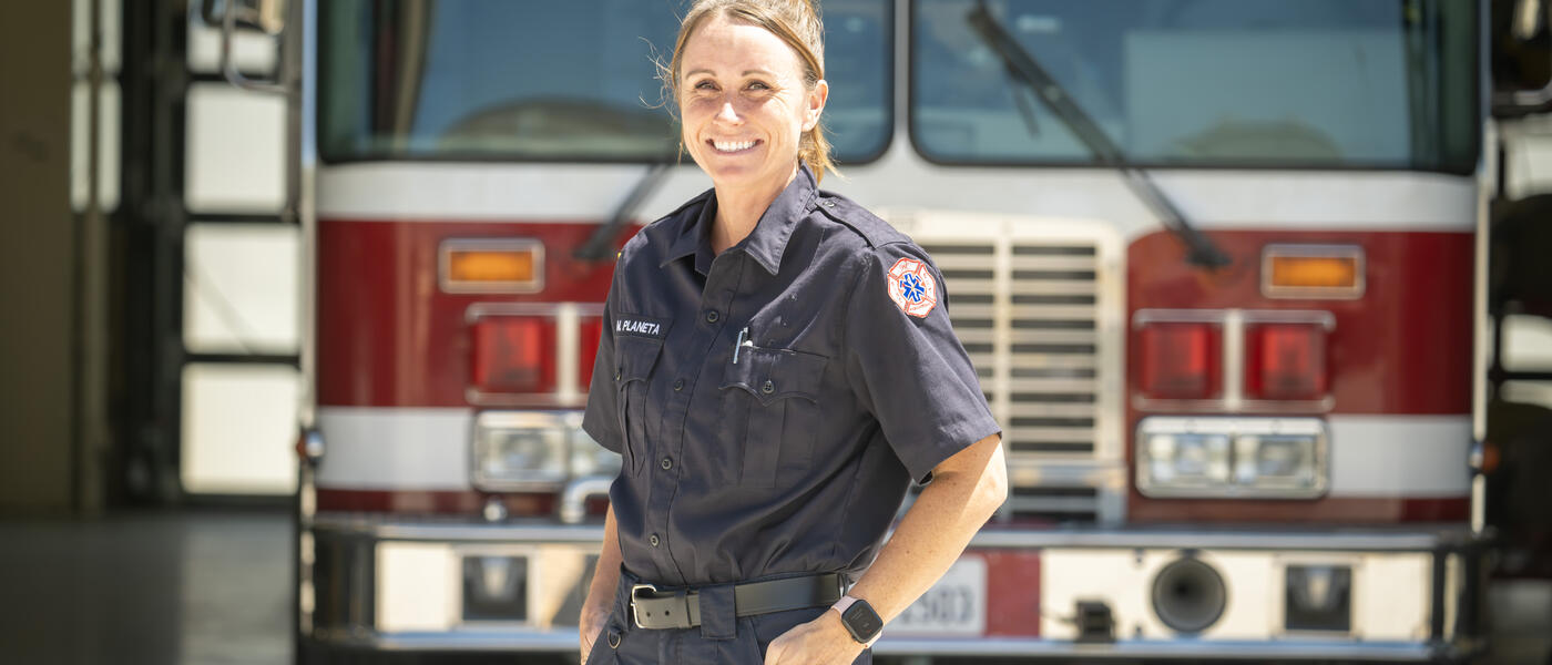 Female fire cadet poses in front of fire engine