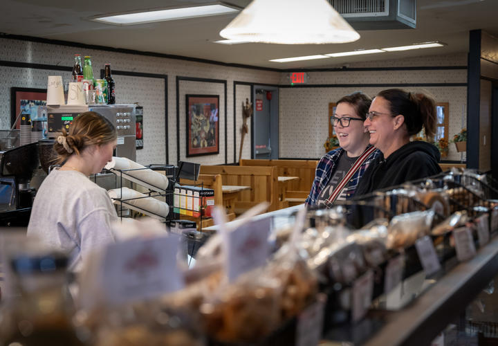 Customers purchase pie at the checkout counter.