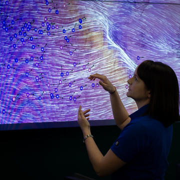 SDG&E Meteorologist stands in front of a monitor depicting high winds