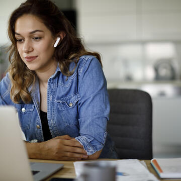 Woman on a computer attending a virtual meeting