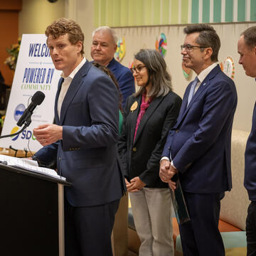Former Congressman and President of Citizens Energy, Joe Kennedy III standing at a podium announcing the donation of EVs to three San Diego County non-profits. 