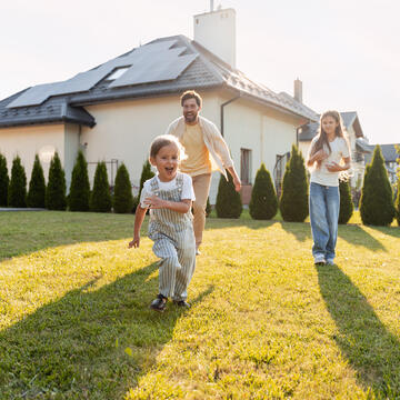 Family looking at home with solar panels