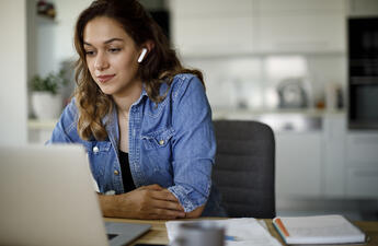 Woman on a computer attending a virtual meeting