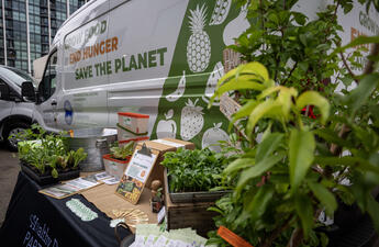 An electric van that was donated to a San Diego County non-profit, surrounded by greenery.