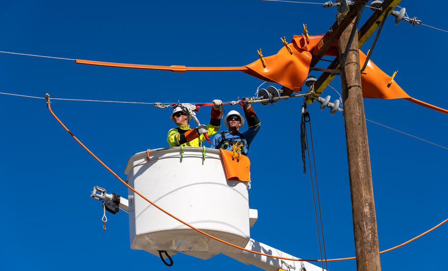 Linemen in bucket truck repairing lines