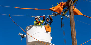 Linemen in bucket truck repairing lines