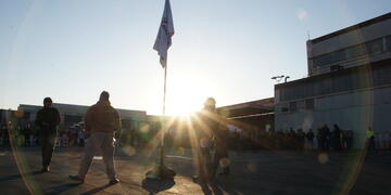 Three crew members observe a recognition flag