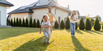 Family looking at home with solar panels