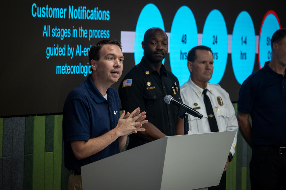Brian D'Agostino presents from the podium inside the emergency operations center
